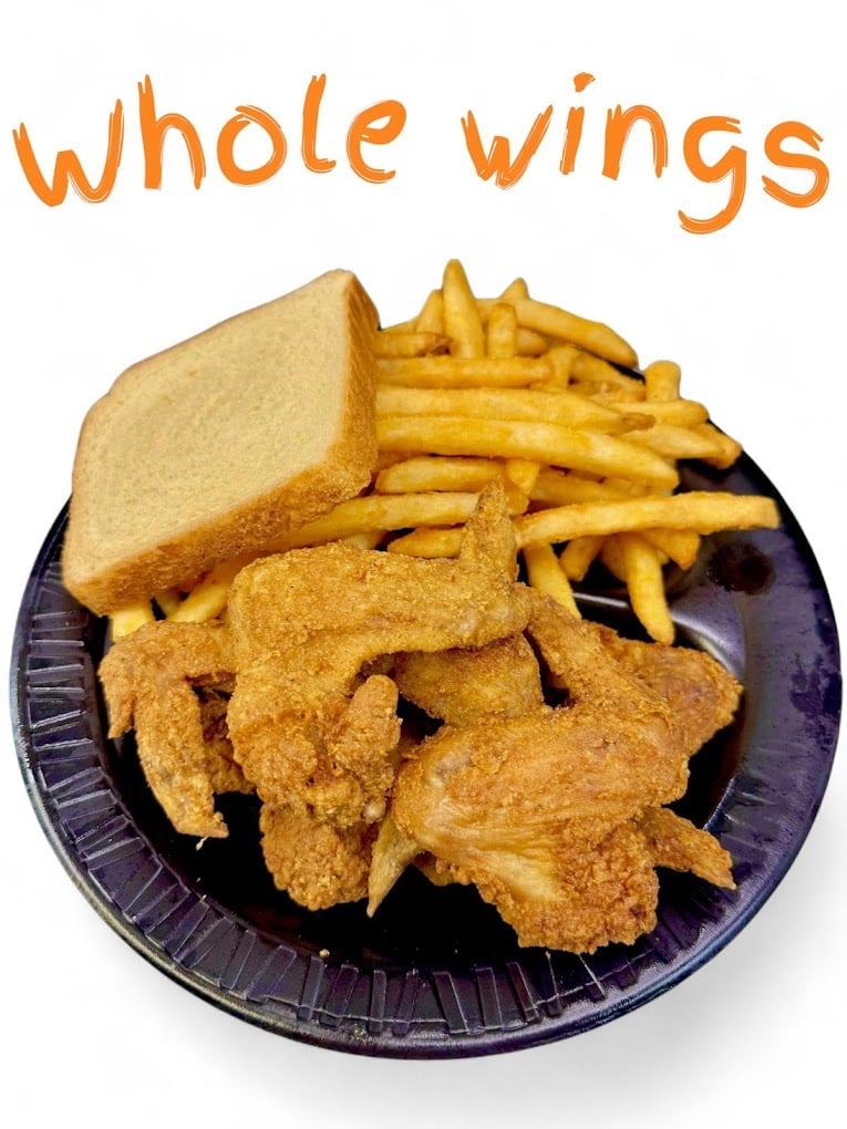 Plate of fried chicken wings with French fries and white bread labeled Whole Wings